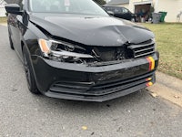 a black volkswagen jetta parked in a driveway