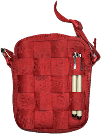 a red crossbody bag with pens and pencils inside