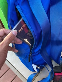 a person holding a backpack with a passport in it