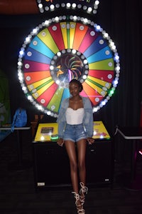 a woman posing in front of a colorful wheel