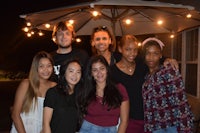 a group of people posing for a picture under an umbrella