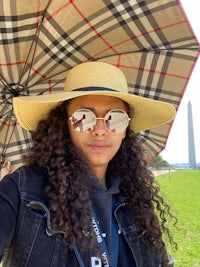 a woman holding an umbrella in front of the washington monument